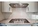 Close up on a stovetop with granite countertops and white subway tile backsplash at 4009 Grace Pointe Dr # 101, Indian Trail, NC 28079