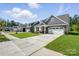 A row of modern gray homes with well-manicured lawns and sidewalks on a sunny day at 4009 Grace Pointe Dr # 101, Indian Trail, NC 28079