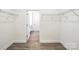Spacious walk-in closet with wood-look flooring and shelving offers plenty of storage space at 4009 Grace Pointe Dr # 101, Indian Trail, NC 28079