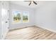 A bright bedroom featuring wood floors, a ceiling fan and a large window overlooking the street at 402 Walker St, Kannapolis, NC 28081