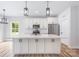 Charming kitchen features an island, white cabinetry, stainless appliances, and modern lighting at 402 Walker St, Kannapolis, NC 28081
