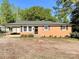 Charming brick home featuring classic black shutters and a convenient carport for covered parking at 418 Dallas Stanley Hwy, Dallas, NC 28034
