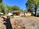 Side view of a cute brick house, complemented by a beautiful blue sky and lush green trees at 418 Dallas Stanley Hwy, Dallas, NC 28034