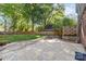 Backyard featuring stone patio with a firepit, a wooden fence, and mature trees at 6117 Brace Rd, Charlotte, NC 28211