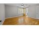 Bright bedroom with hardwood floors, a window with blinds, and a sliding barn door to the bathroom at 6117 Brace Rd, Charlotte, NC 28211