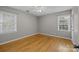 Bright bedroom with hardwood floors, two windows, and a ceiling fan at 6117 Brace Rd, Charlotte, NC 28211
