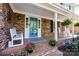 Inviting front porch with blue door, rocking chairs, and flower planters at 6117 Brace Rd, Charlotte, NC 28211