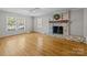 Sunlit living room with hardwood floors and a brick fireplace at 6117 Brace Rd, Charlotte, NC 28211