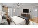 Main bedroom featuring a sleek TV, stylish decor, and barn door to the ensuite bathroom at 6117 Brace Rd, Charlotte, NC 28211