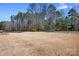 Large backyard with mature trees and a trampoline, offering space for recreation at 835 Yucatan Dr, Waxhaw, NC 28173