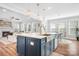 Open-concept kitchen boasts a spacious island with seating, modern pendant lighting, and stainless steel sink at 835 Yucatan Dr, Waxhaw, NC 28173