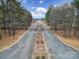 Long, paved driveway leading to an upscale neighborhood, lined with mature trees and fencing at 856 Bellegray Rd, Clover, SC 29710