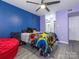 Colorful bedroom with two-tone walls, complete with ceiling fan, and a window offering natural light at 9427 S Vicksburg Park Ct, Charlotte, NC 28210