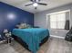 Bright bedroom features a ceiling fan, blue accent wall, and large window for ample natural light at 9427 S Vicksburg Park Ct, Charlotte, NC 28210