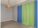 Cozy bedroom featuring gray walls, wood-look floors, and green and blue window coverings at 9427 S Vicksburg Park Ct, Charlotte, NC 28210