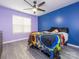 Inviting bedroom showcasing a vibrant accent wall, ceiling fan, and large window, creating a bright and cozy ambiance at 9427 S Vicksburg Park Ct, Charlotte, NC 28210