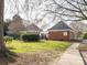 View of the community pool entrance and surrounding greenery from an open grass field at 9427 S Vicksburg Park Ct, Charlotte, NC 28210