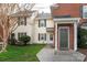 Exterior view of a cream and brick townhome with well-maintained landscaping and green shutters at 9427 S Vicksburg Park Ct, Charlotte, NC 28210