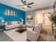 Comfortable living room featuring stylish furniture, sleek floors, and a striking blue accent wall with colorful artwork at 9427 S Vicksburg Park Ct, Charlotte, NC 28210