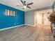 Inviting living room with sleek vinyl flooring, vibrant blue accent wall, and a modern ceiling fan at 9427 S Vicksburg Park Ct, Charlotte, NC 28210