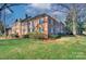 Corner view of a brick apartment building with mature trees, landscaped lawn, and an iron fence at 101 S Laurel Ave # 72A, Charlotte, NC 28207