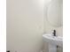 Modern powder room featuring a sleek pedestal sink and round mirror at 10405 Briarhurst Pl # 18, Mint Hill, NC 28227