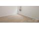 This empty bedroom features neutral carpet and a window, ready for personalization and comfortable living at 10405 Briarhurst Pl # 18, Mint Hill, NC 28227