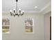 Dining room featuring a modern chandelier and two windows with views at 10405 Briarhurst Pl # 18, Mint Hill, NC 28227
