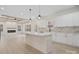 Open-concept kitchen and living room with white cabinets, a central island, and a cozy fireplace at 10405 Briarhurst Pl # 18, Mint Hill, NC 28227