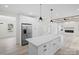 Open concept kitchen with white cabinets, stainless steel appliances, and a large island at 10405 Briarhurst Pl # 18, Mint Hill, NC 28227