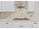 Close-up of the modern kitchen cooktop, marble backsplash, and sleek exhaust hood at 10405 Briarhurst Pl # 18, Mint Hill, NC 28227
