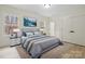 Staged main bedroom featuring large windows, ensuite access, and neutral decor at 10405 Briarhurst Pl # 18, Mint Hill, NC 28227