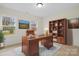 Home office with wood desk, bookcase, and ample natural light at 10405 Briarhurst Pl # 18, Mint Hill, NC 28227
