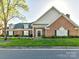 Well-maintained brick home with manicured lawn, flowering bushes, and a welcoming front entrance at 11406 Olde Turnbury Ct, Charlotte, NC 28277