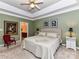 Main bedroom featuring tray ceiling, ensuite access, and stylish decor at 11406 Olde Turnbury Ct, Charlotte, NC 28277