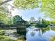 Scenic view of a charming gazebo on a pond with a bridge, fountain, and lush greenery at 11406 Olde Turnbury Ct, Charlotte, NC 28277
