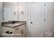 Bathroom vanity featuring granite counters, white cabinets, modern fixtures and ample lighting at 121 N Prestwick Way # 43, Mooresville, NC 28115