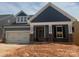 Charming single-Gathering home featuring a 2-car garage and a welcoming front porch with stone and siding accents at 121 N Prestwick Way # 43, Mooresville, NC 28115