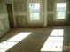 A bright, unfinished living room with two windows looking out at a large yard and neighborhood beyond at 122 Peppervine Ln, Statesville, NC 28625