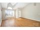 Bright living room features vaulted ceilings, a large window overlooking the front yard and hardwood floors at 12810 English Walnut Ln, Charlotte, NC 28215