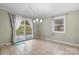 Bright dining room with tile floors, modern chandelier, and sliding glass doors to the backyard at 1525 16Th Avenue Nw Cir, Hickory, NC 28601