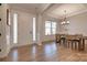 Open foyer showcasing hardwood floors, wainscoting, and a view into the dining room with abundant natural light at 15606 Walnut Hill Dr, Charlotte, NC 28278
