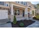 Close-up view of the front porch featuring stone and brick accents, decorative wreath, and well-maintained landscaping at 15606 Walnut Hill Dr, Charlotte, NC 28278