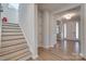 Hallway with hardwood floors and a staircase leading to the upper level, offering a glimpse of the foyer at 15606 Walnut Hill Dr, Charlotte, NC 28278