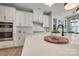 Bright kitchen with an island, white cabinets, stainless steel appliances, and modern pendant lights at 15606 Walnut Hill Dr, Charlotte, NC 28278