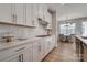 Well-lit kitchen featuring white cabinets, modern backsplash, gas range, and a view to the dining space at 15606 Walnut Hill Dr, Charlotte, NC 28278