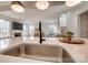 Modern kitchen island with a sink, quartz countertop, and seamless transition to the living area at 15606 Walnut Hill Dr, Charlotte, NC 28278