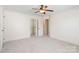 Spacious bedroom with neutral carpet, ceiling fan, white trim and open doors to closets at 1730 Townsend Ln, Rock Hill, SC 29730