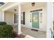 Inviting front porch featuring classic white columns, a green front door with glass, and stylish overhead lighting at 1730 Townsend Ln, Rock Hill, SC 29730