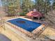 Aerial view of a community pool with a building featuring a red roof and grassy areas around the fenced perimeter at 1730 Townsend Ln, Rock Hill, SC 29730